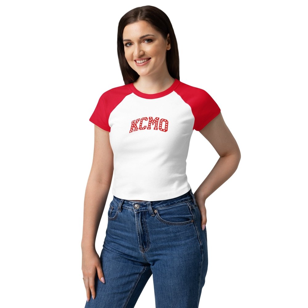 Model wearing a white and red HAGS KCMO Kansas City baby tee with red polka-dot lettering.