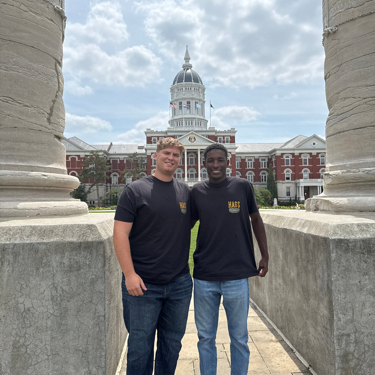 Two people standing on at the University Of Missouri Columns with Hags Clothing on 