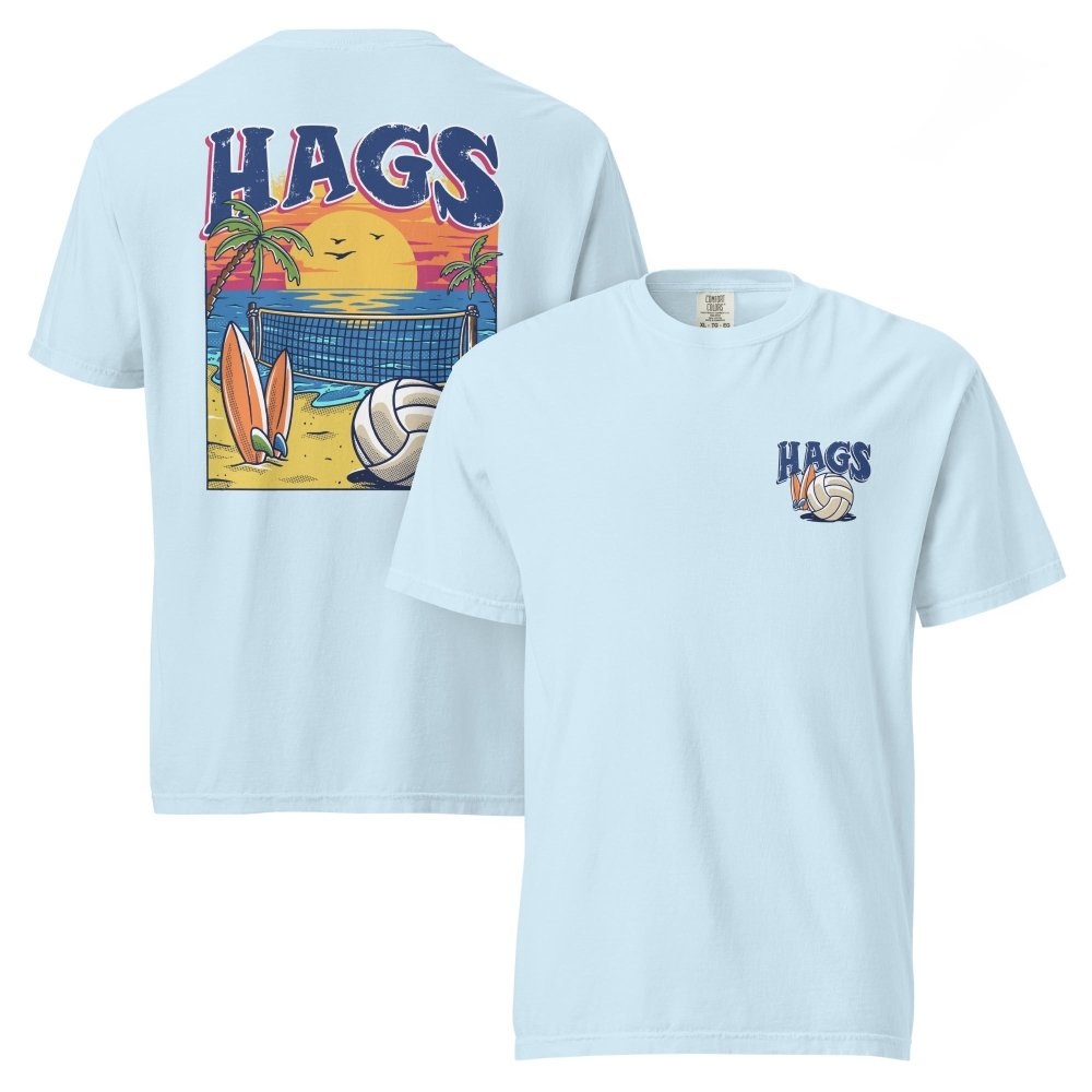 Front and back views of light blue HAGS beach volleyball sunset T-shirt, showing small HAGS volleyball chest logo and a volleyball, surfboards and beach sunset graphic.
