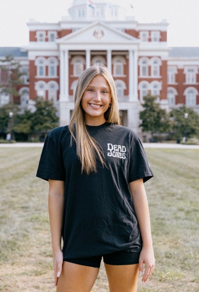 Woman wearing the black HAGS Dead Jones Band skull T-shirt outdoors.