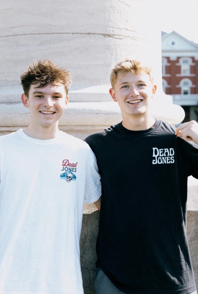 Two people wearing white vintage beer and black skull Dead Jones Band T-shirts.