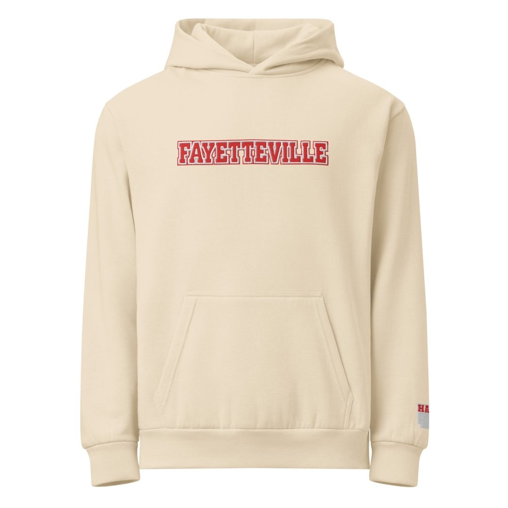 Front view of ivory HAGS Fayetteville Arkansas embroidered hoodie, showing red FAYETTEVILLE chest lettering.