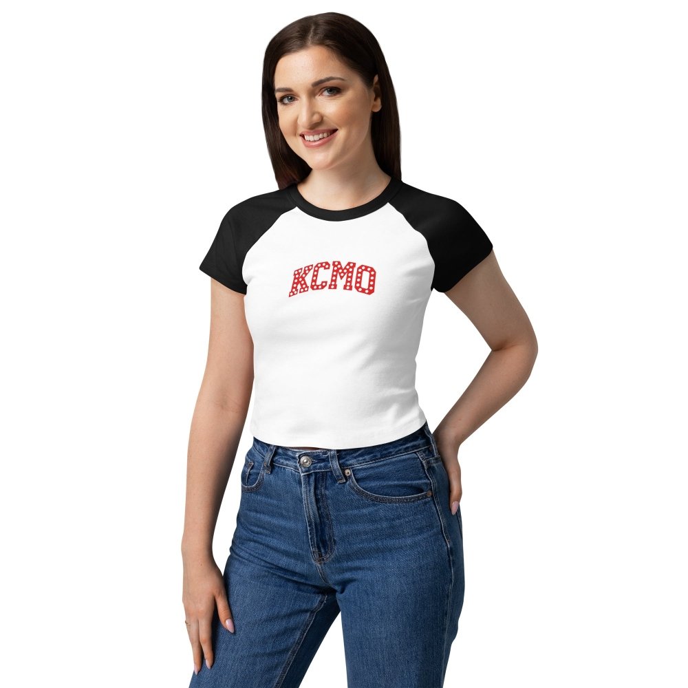 Model wearing a white and black HAGS KCMO Kansas City baby tee with red polka-dot lettering.