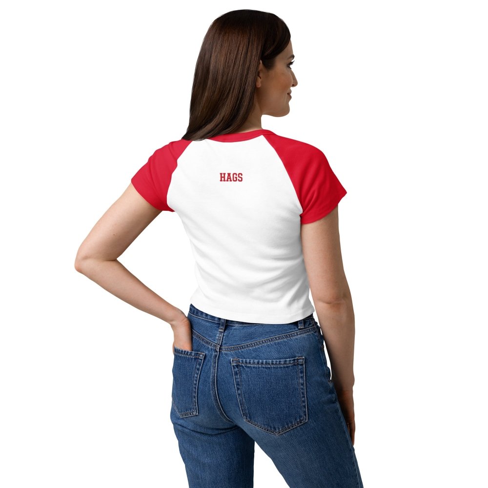 Model wearing a white and red HAGS KCMO baby tee, viewed from behind with a small HAGS logo below the collar.