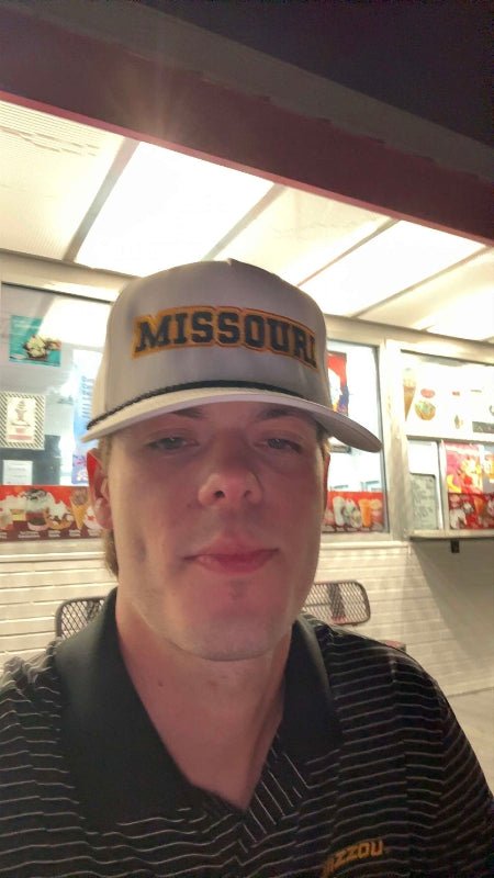 Person wearing a white HAGS Missouri rope hat with black and gold MISSOURI embroidery.
