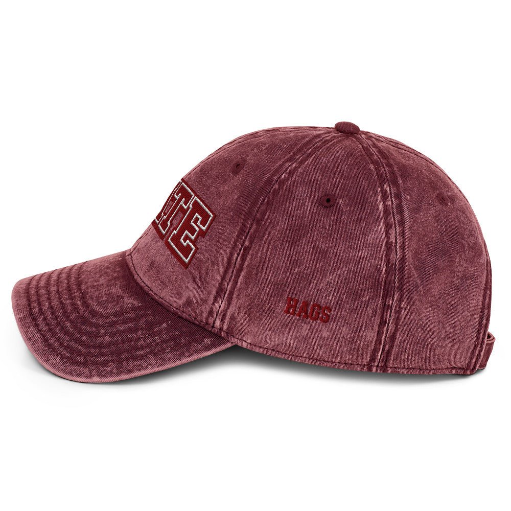 Angled front view of burgundy HAGS State washed dad hat, showing maroon and white STATE embroidery.