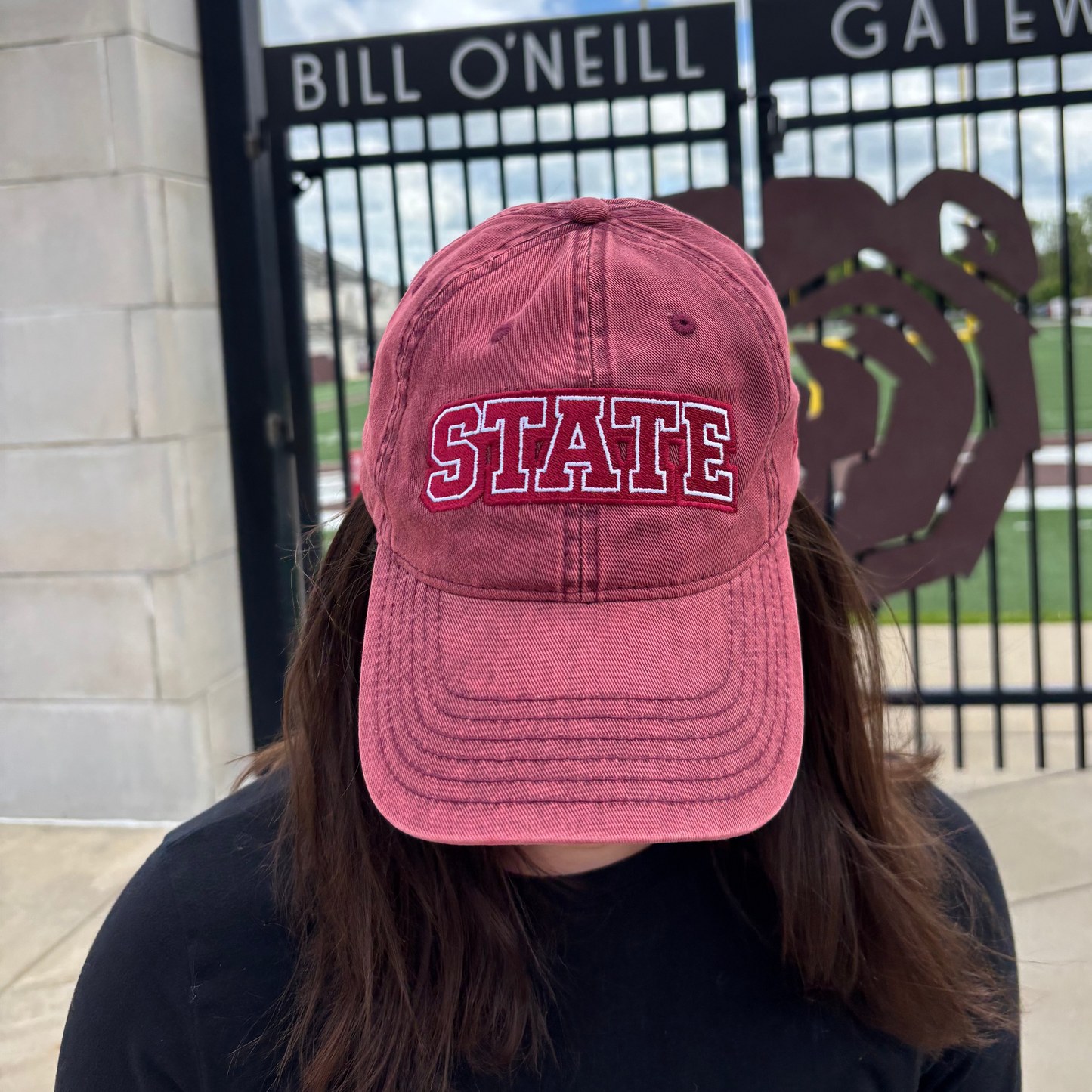 Person wearing a burgundy HAGS STATE embroidered dad hat outdoors.