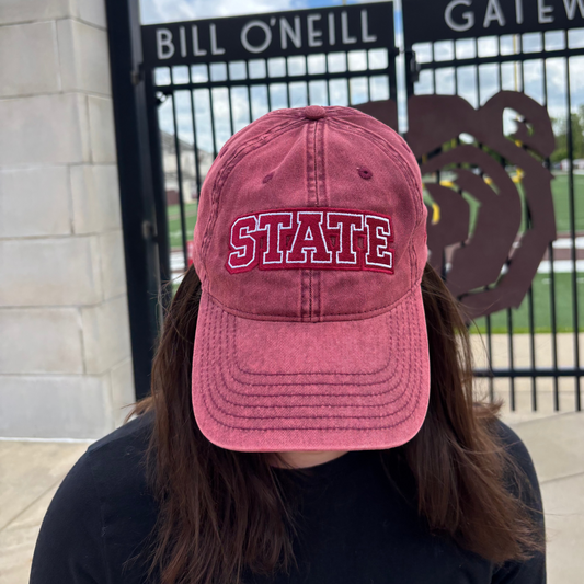 Person wearing a burgundy HAGS STATE embroidered dad hat outdoors.