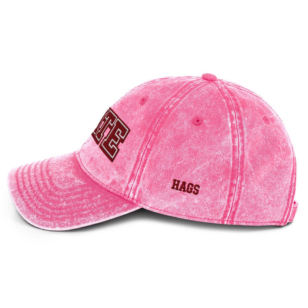 Angled front view of pink HAGS State washed dad hat, showing maroon and white STATE embroidery.