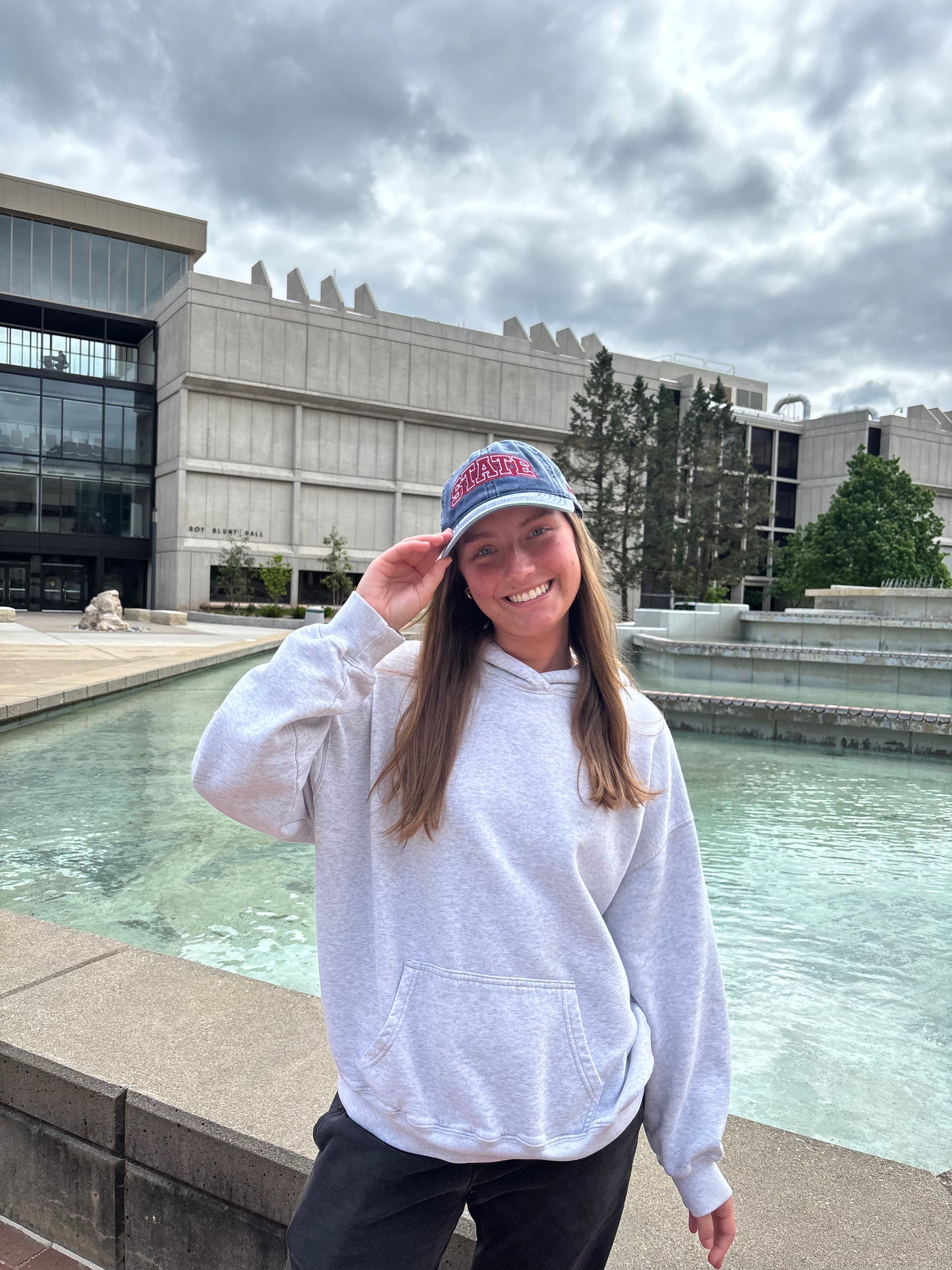 Person wearing a washed navy HAGS STATE embroidered dad hat outdoors.